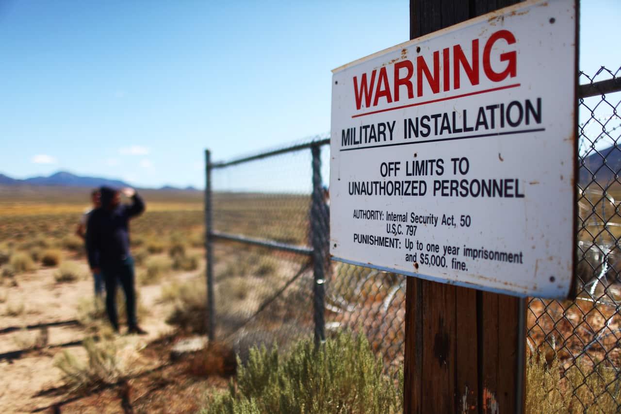 People gather at an entrance gate to the Nevada Test and Training Range, located near Area 51.
