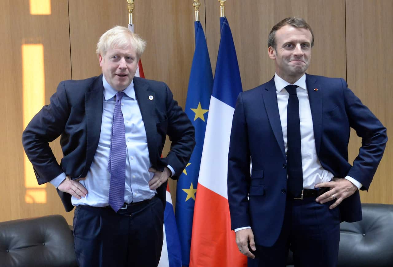 Britain's Prime Minister Boris Johnson (L) poses with French President Emmanuel Macron during a bi-lateral meeting on the sidelines of a European Union Summit.