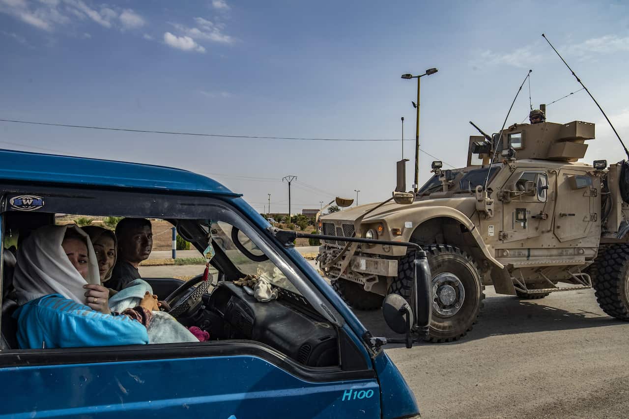 A US military vehicle drives on a road after US forces pulled out of their base in the Northern Syriain town of Tal Tamr on October 20, 2019