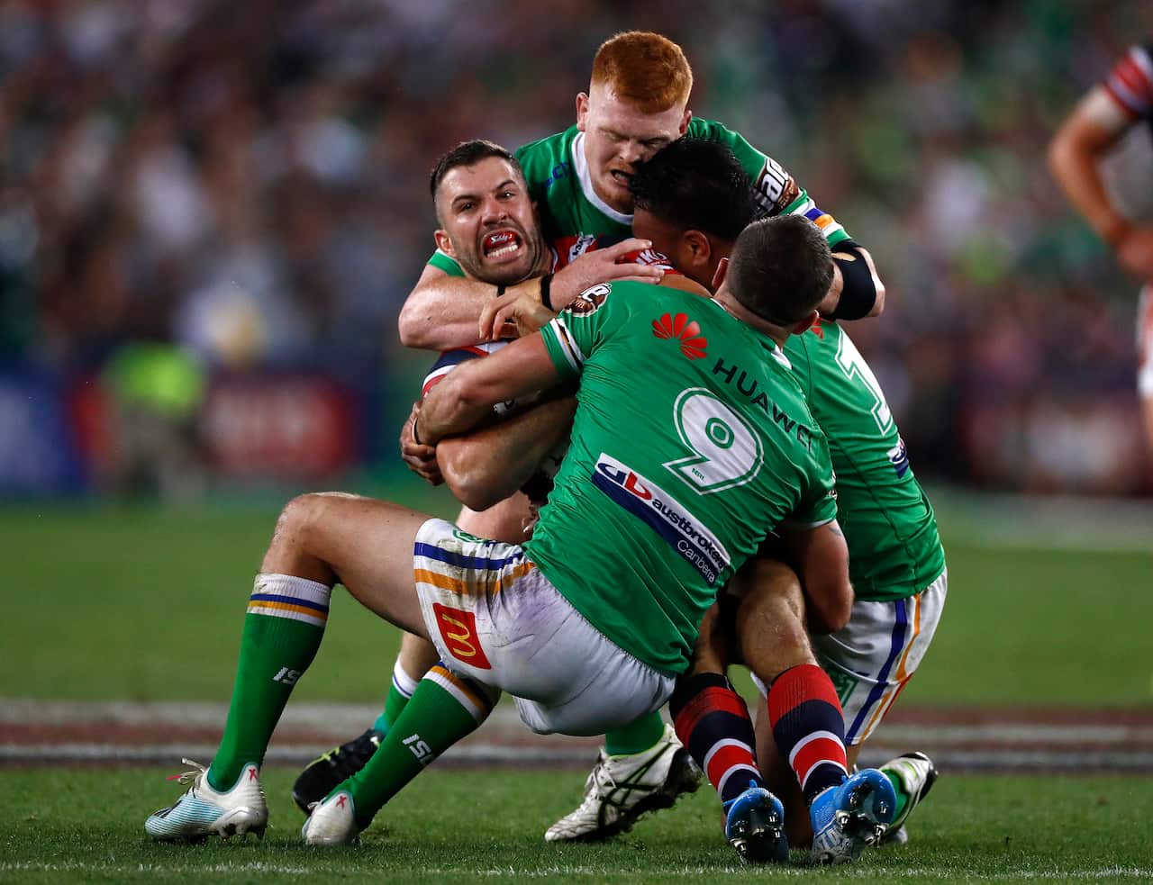 James Tedesco of the Roosters is tackled by Corey Horsburgh of the Raiders.