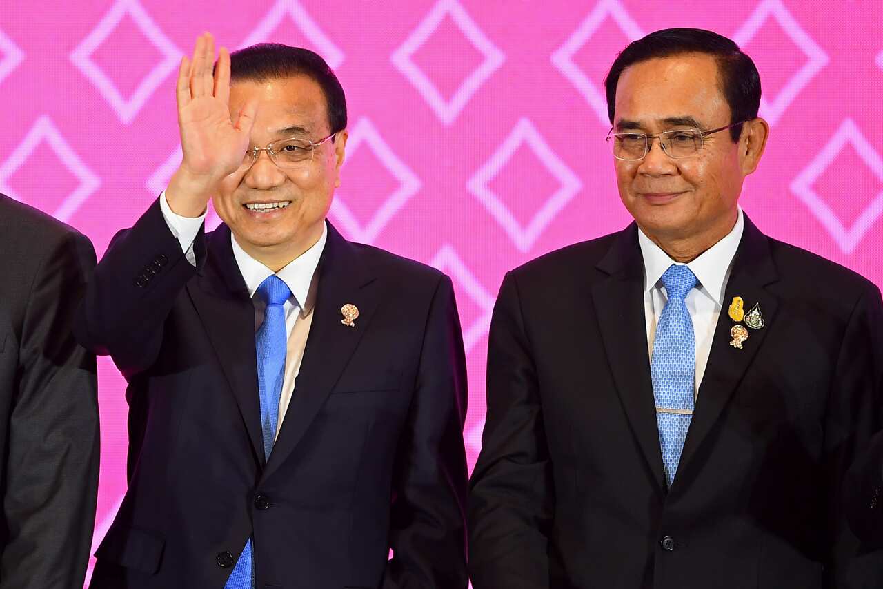 China's Premier Li Keqiang (L) waves beside Thailand's Prime Minister Prayut Chan-O-Cha during the 22nd ASEAN-China Summit in Bangkok.