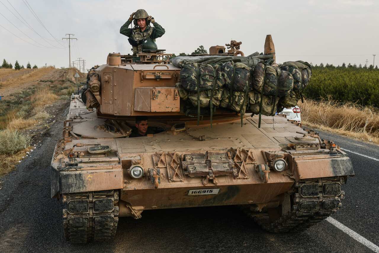 A Turkish soldier is seen on an army tank before moving towards the Syrian border.