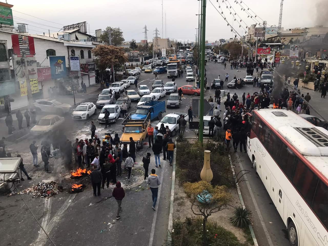 Protesters set fire to debris and block the roads in Tehran during a protest against a gasoline price hike.