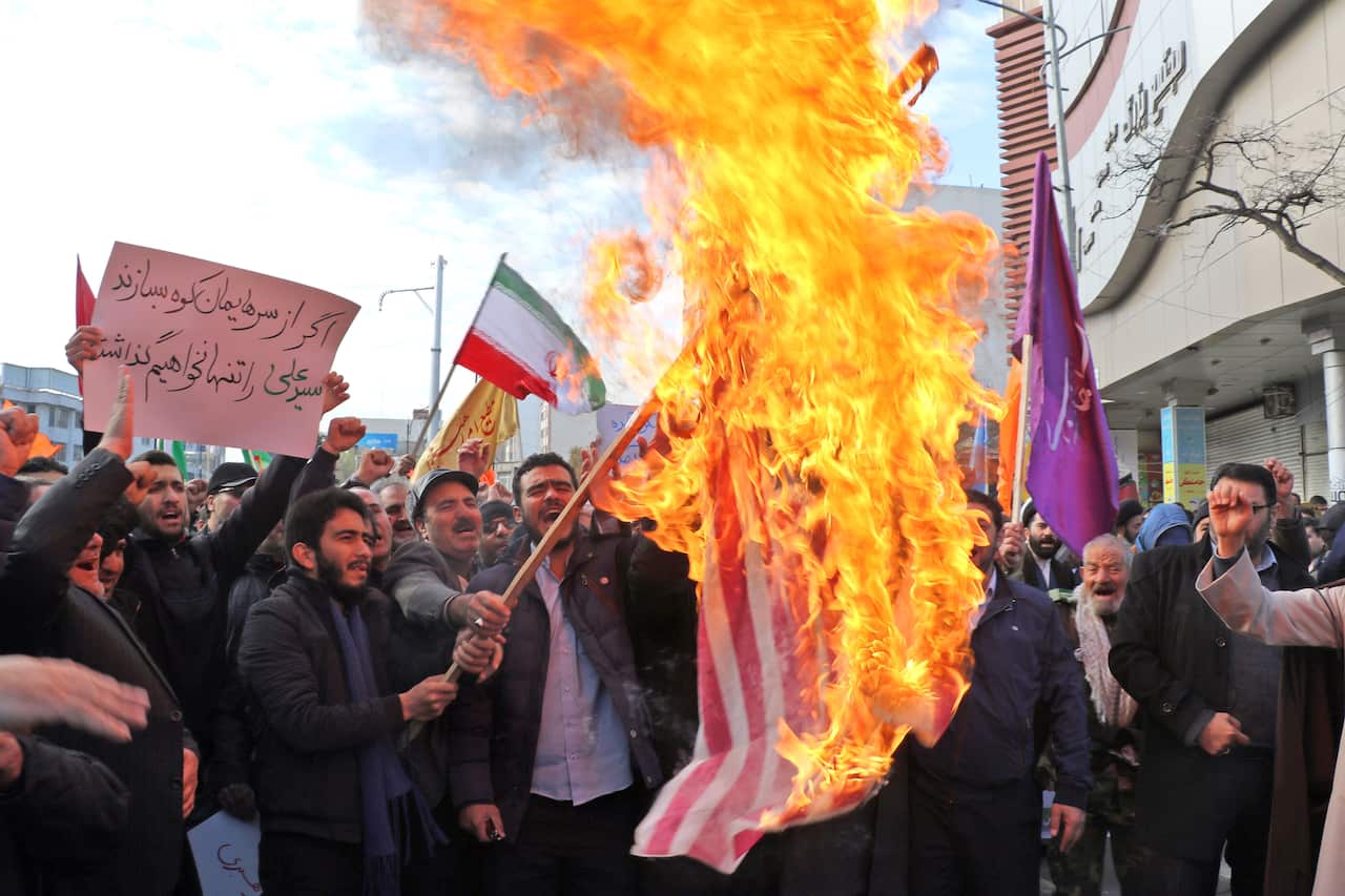 Iranian men burn a US flag during a protest in support of the Islamic republic's government and supreme leader, Ayatollah Ali Khamenei.