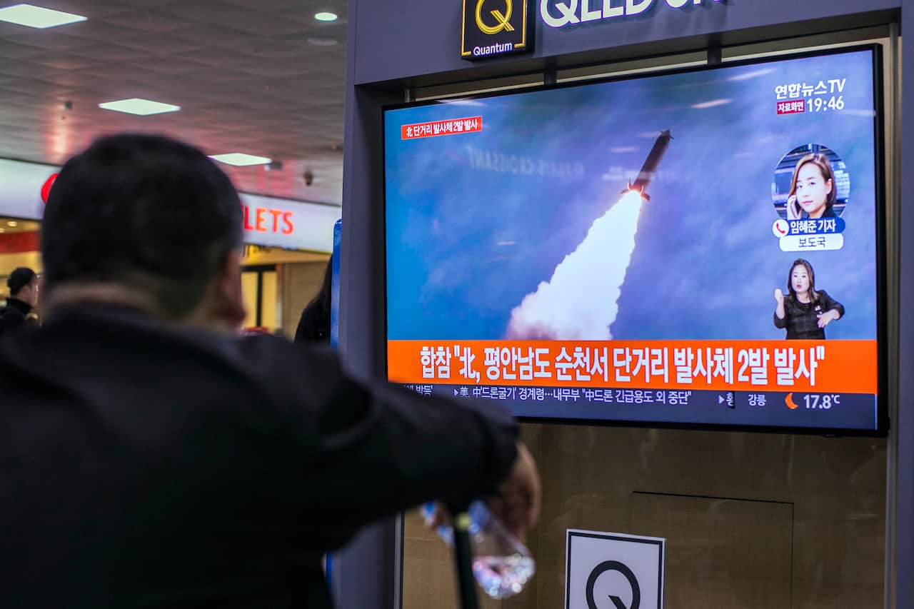 Commuters watch a television broadcast at the Seoul Railway Station with news of the latest North Korean missile launch.