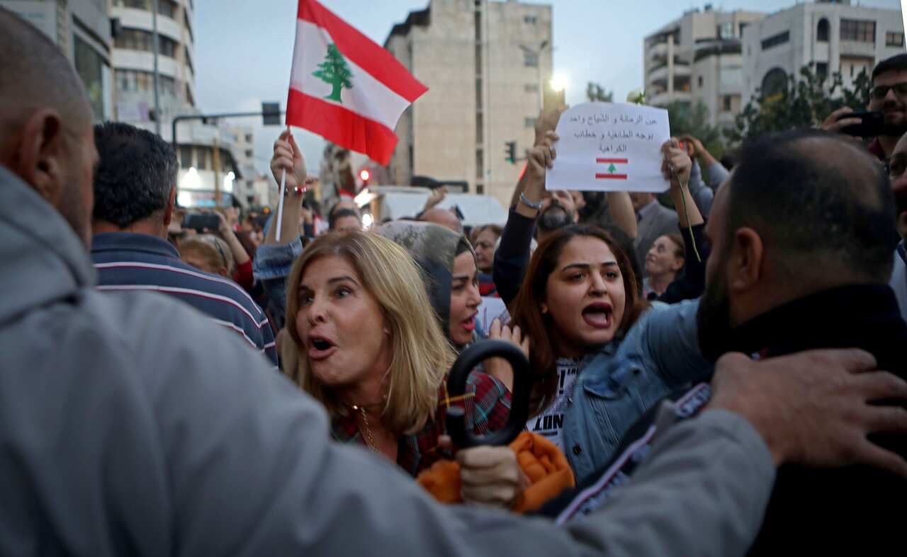 Militants from the Lebanese Amal Shiite movement try to block the road infront of Lebanese women, from the Chrisitan-dominated neighbourhood of Ain al-Remmaneh.