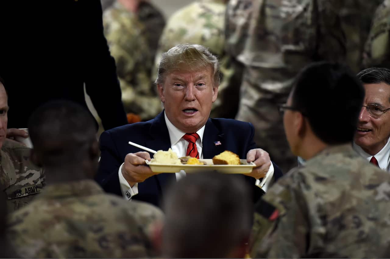 US President Donald Trump serves Thanksgiving dinner to US troops at Bagram Air Field during a surprise visit.