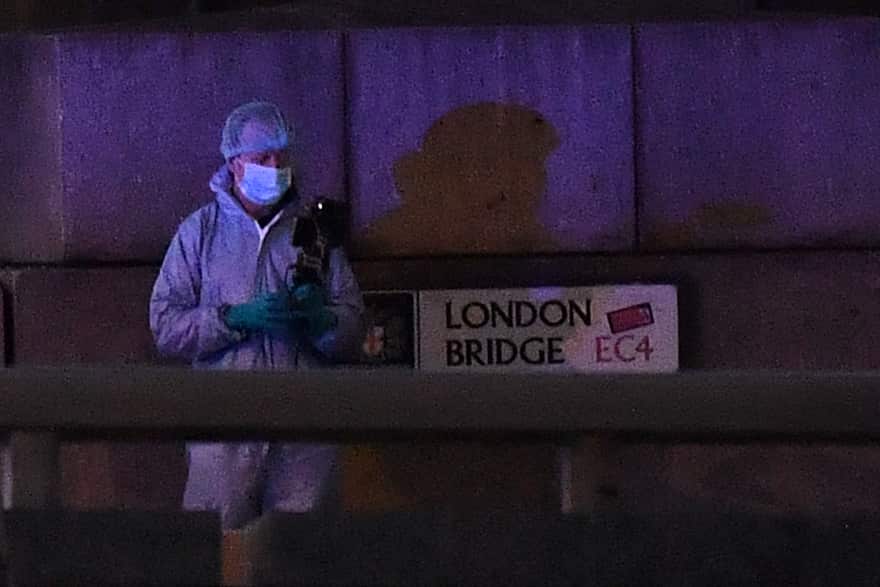 A police forensic officer films at the scene on London Bridge where armed police officers shot the stabbing suspect.