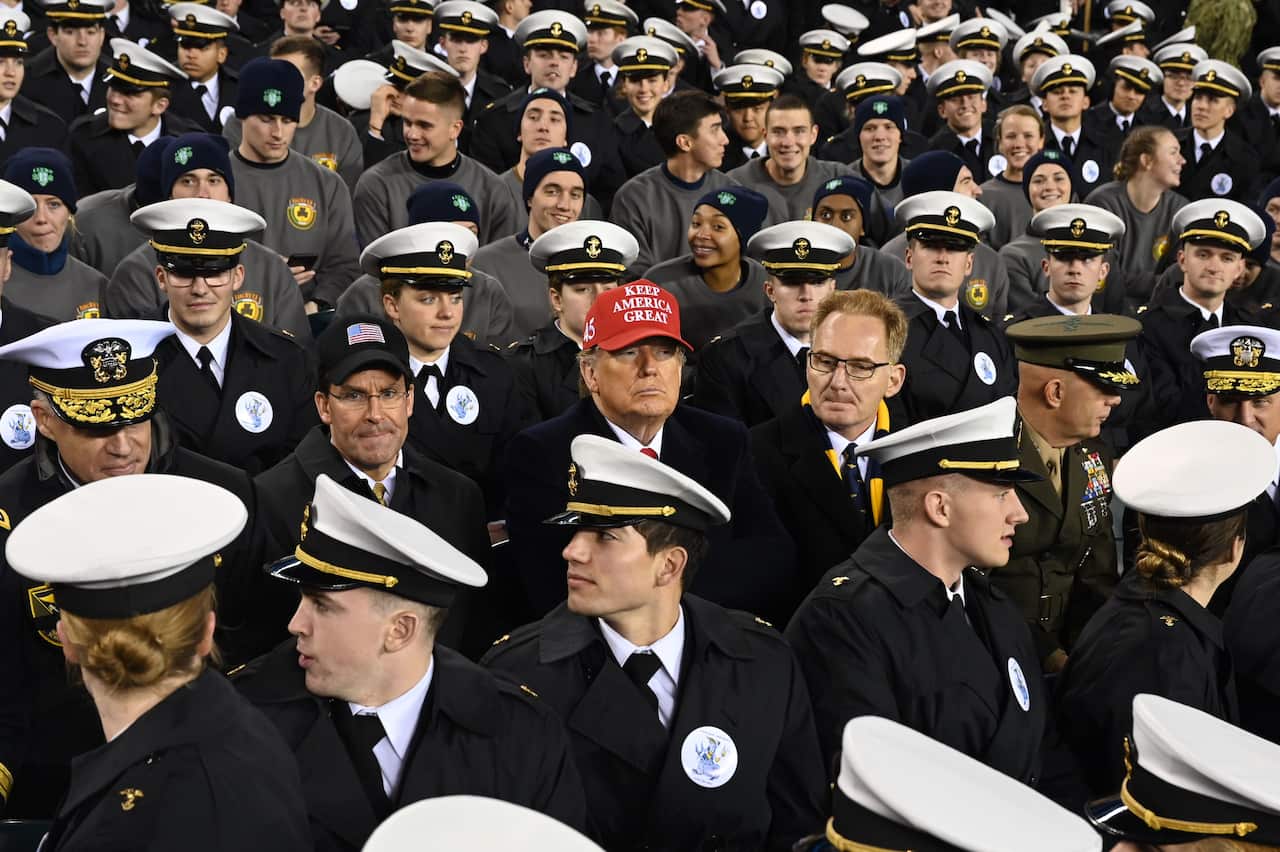 US President Donald Trump (C) joins Naval Academy cadets during the the Army v. Navy American Football game in Philadelphia.
