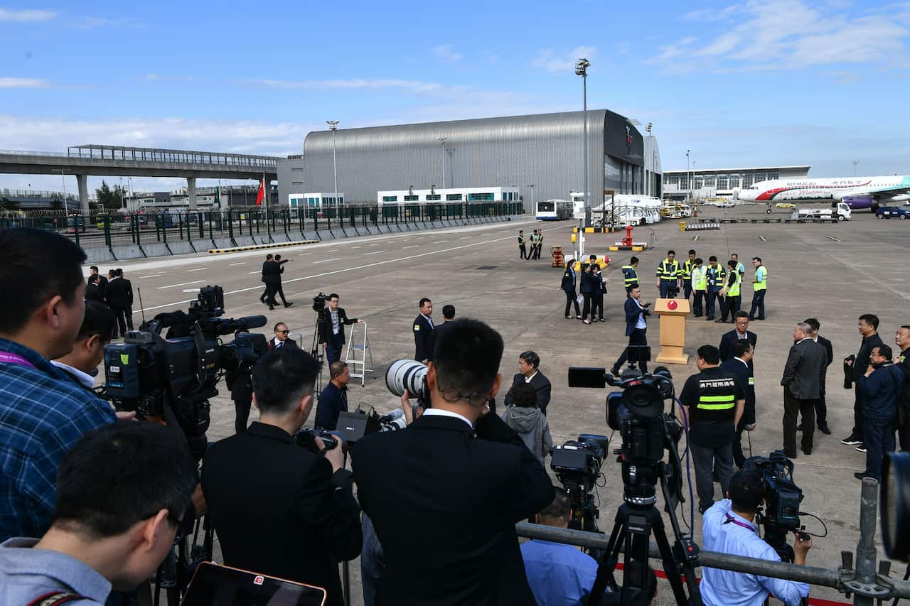 Journalists wait on a stand in front of a lectern where China's President Xi Jinping was due to speak.
