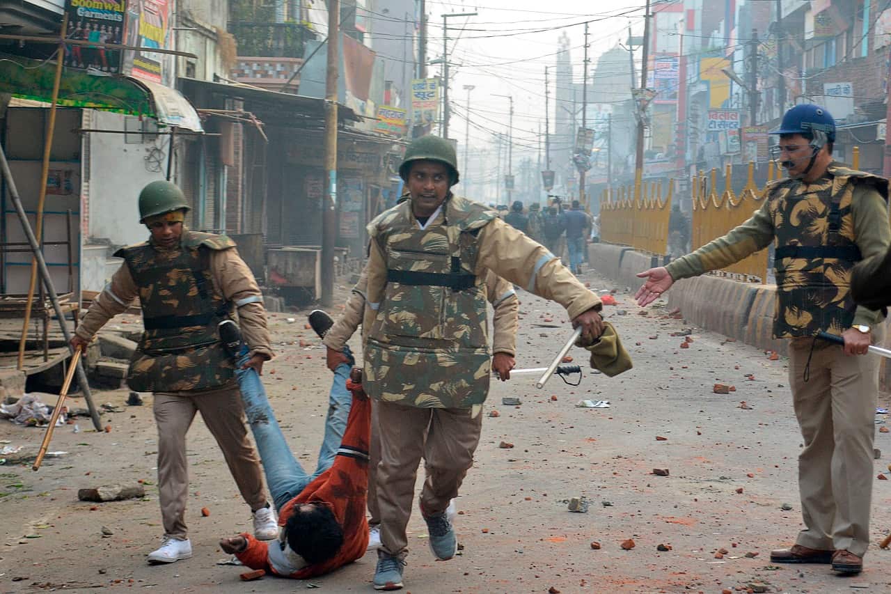 Security personnel detain a protester during demonstrations against India's new citizenship law in Meerut.