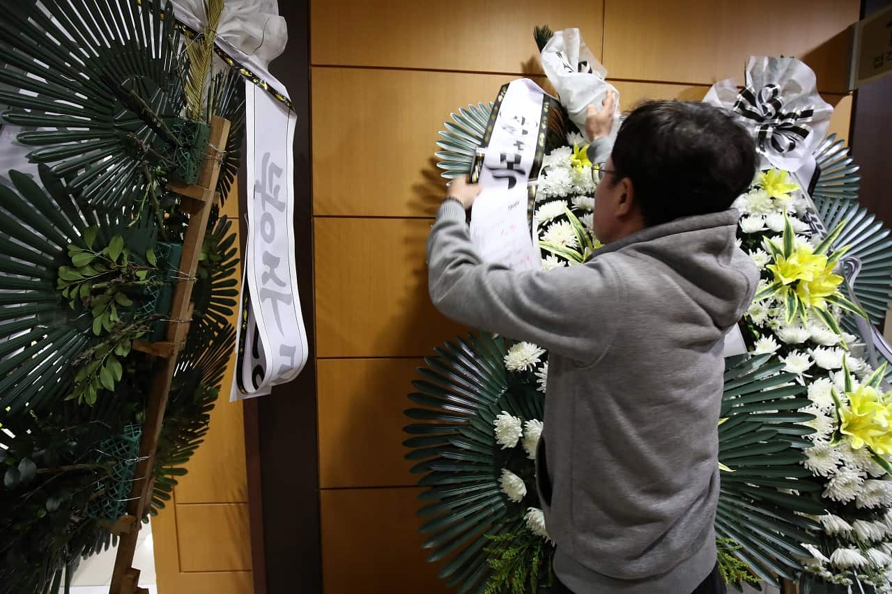 A man prepares flowers for the memorial altar of K-pop star Goo Hara at the Seoul St. Mary's Hospital 