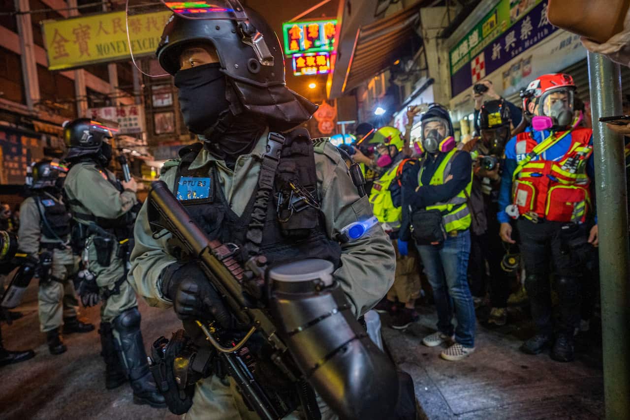 A riot police officer holds a pepper spray projectile gun during demonstrations in Hong Kong.