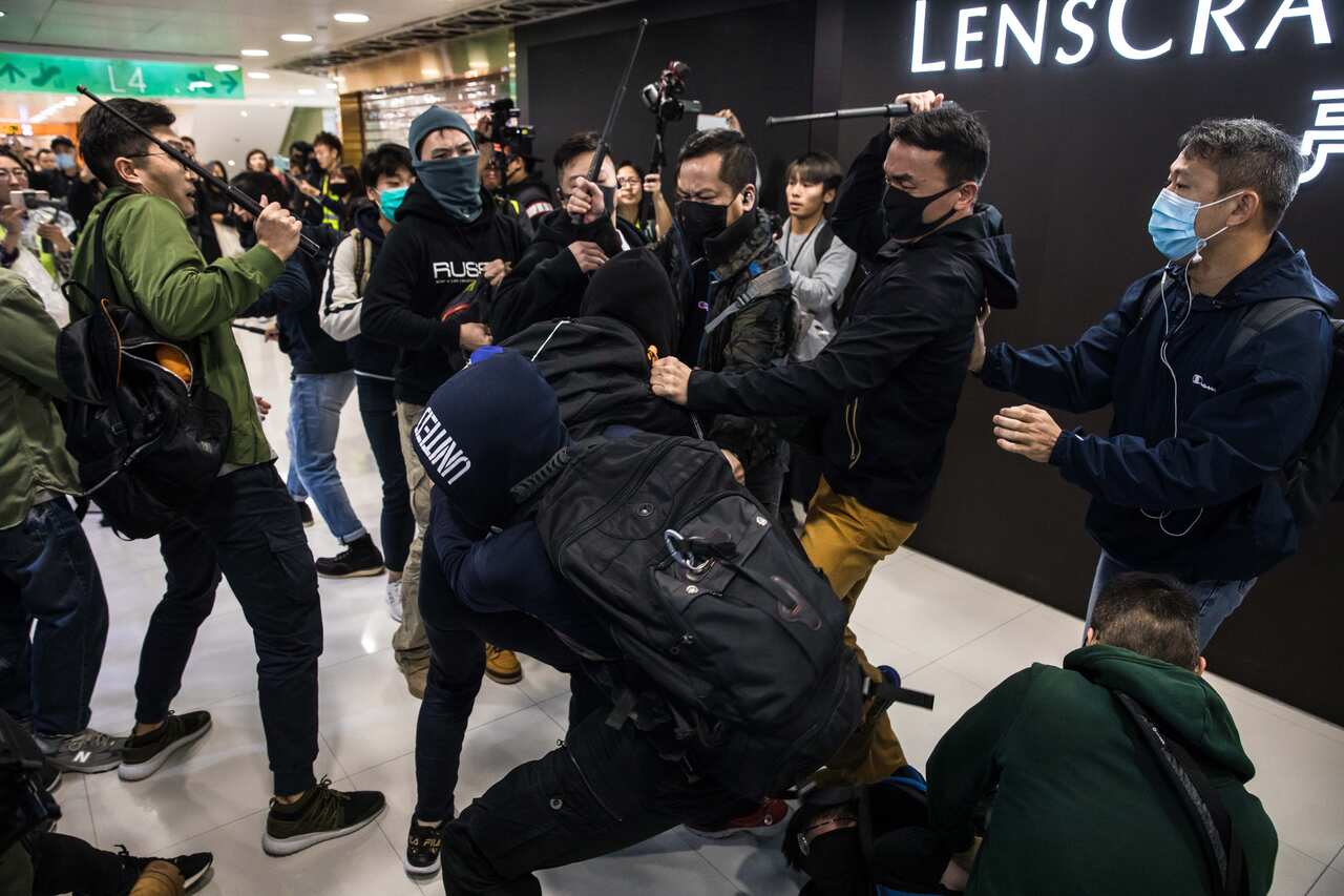 Plainclothes police officers (with batons) clash with pro-democracy protesters during a rally inside a shopping mall in Sheung Shui.
