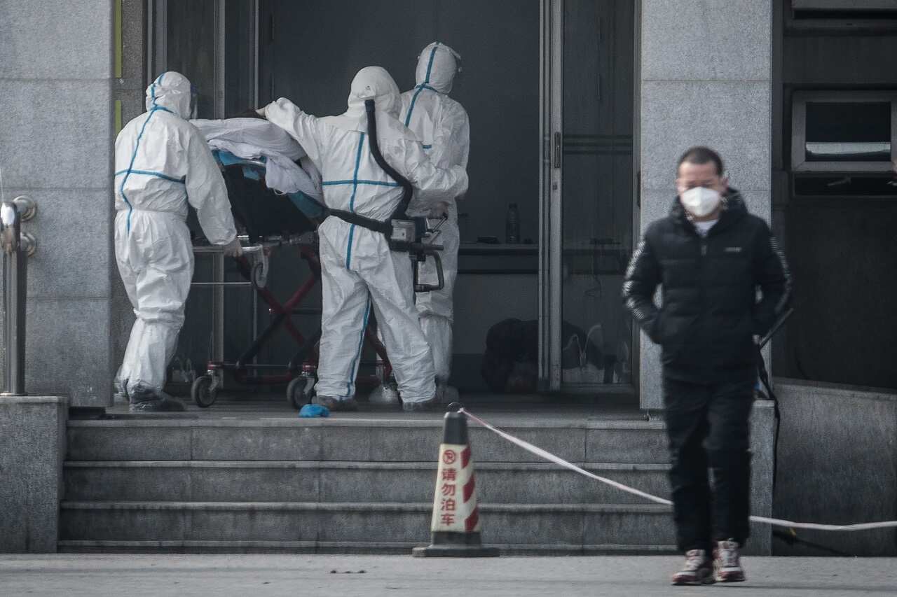 Medical staff members carry a patient into the Jinyintan hospital, where patients infected by the SARS-like virus are being treated