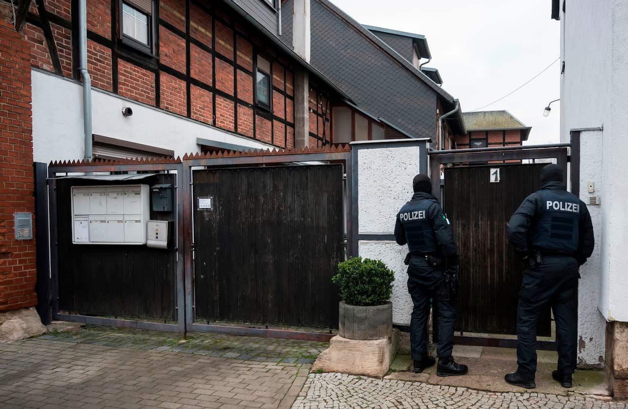 German policemen raid a home in connection with the ban of the neo-Nazi group Combat 18.