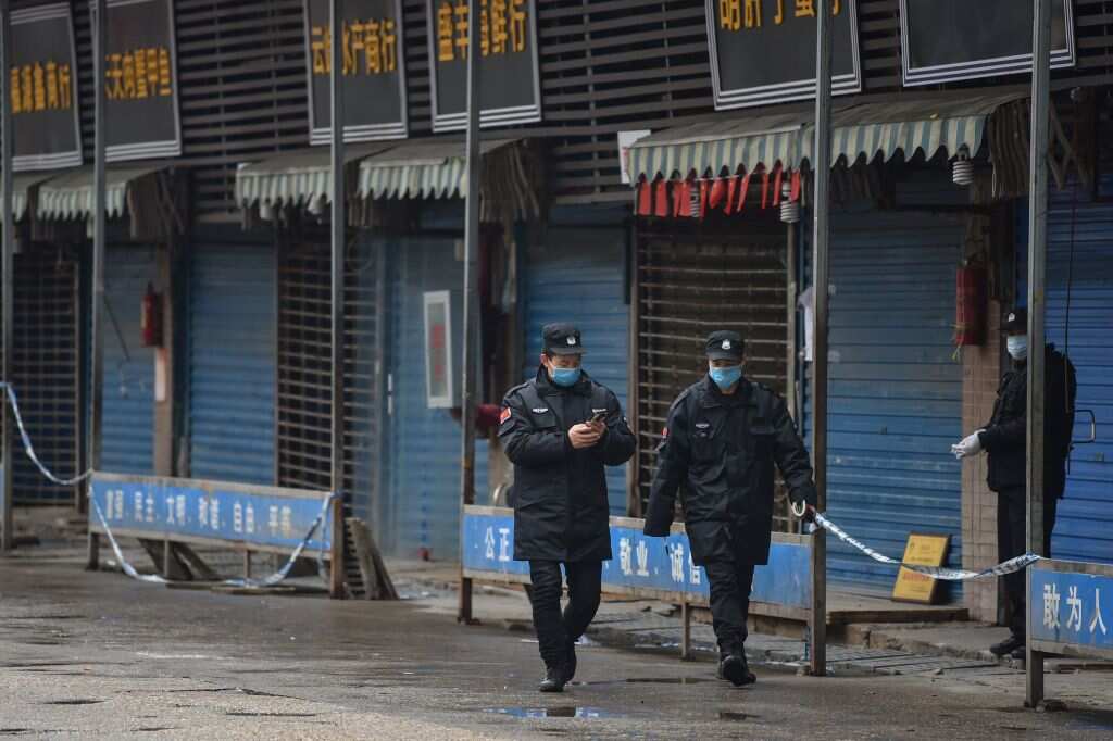 Security guards patrol outside the Huanan Seafood Wholesale Market where the coronavirus was detected in Wuhan