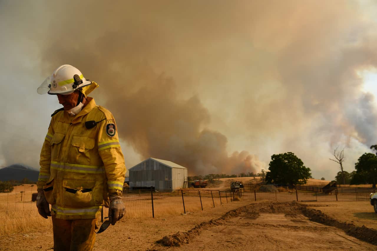 A Rural Fire Service firefighter views a flank of a fire on 11 January, 2020 in Tumburumba, NSW.