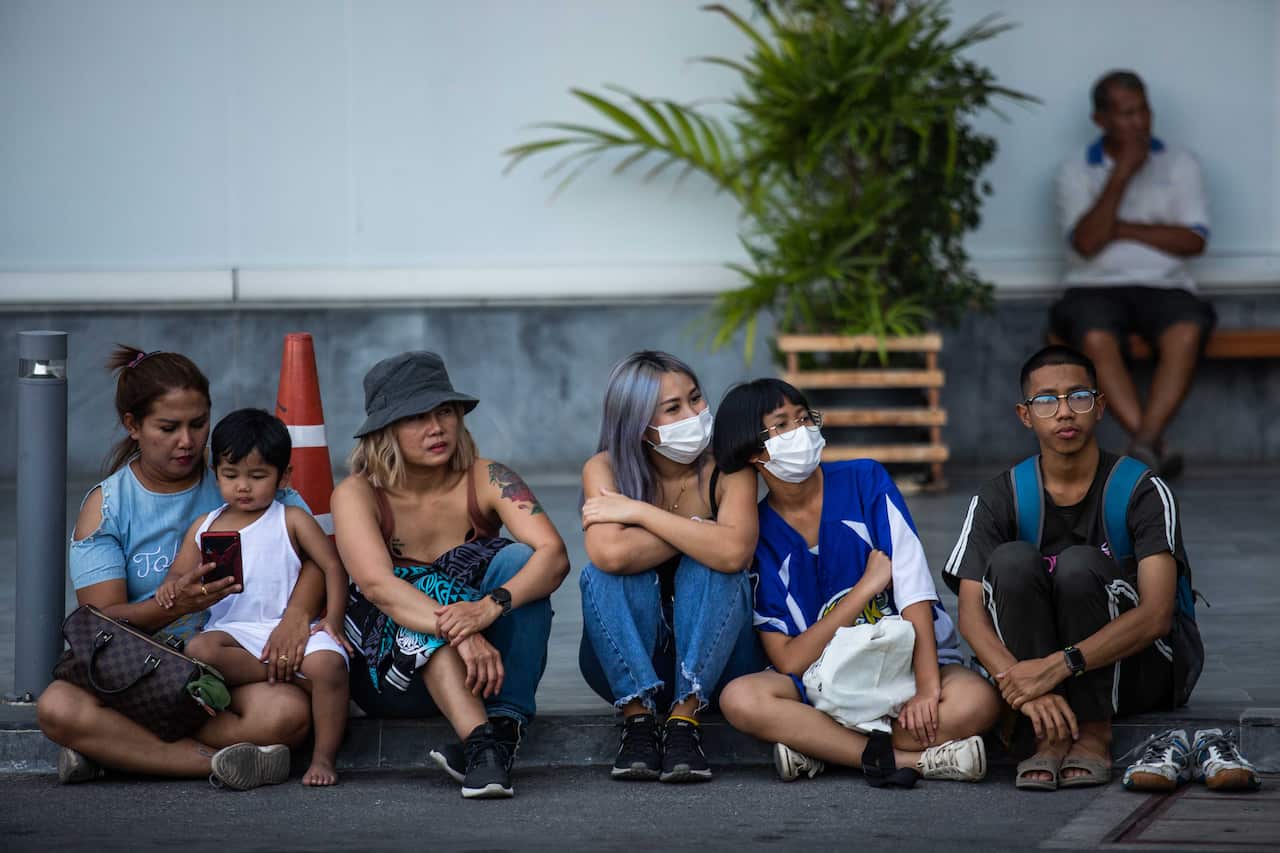 Thai people sit outside of Terminal 21 following the mass  shooting February 9, 2020