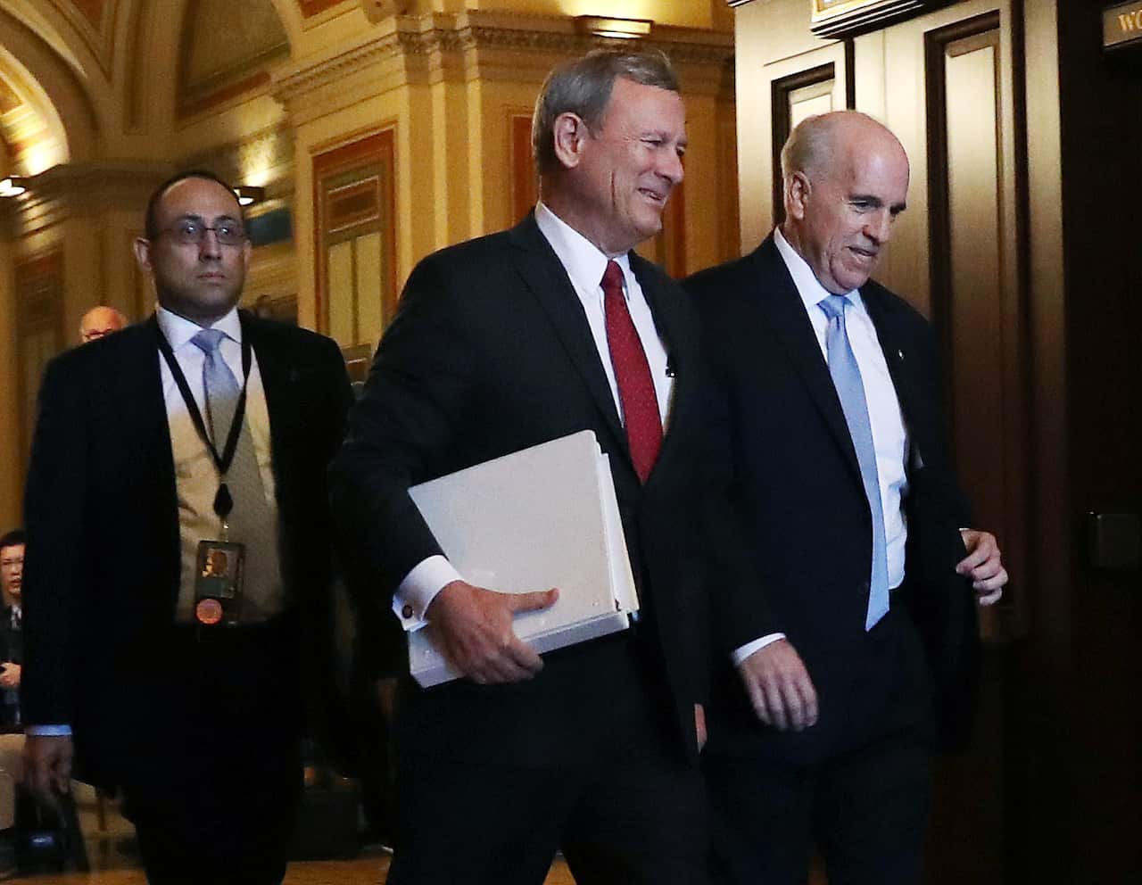 Chief Justice of The U.S. Supreme Court John Roberts (C) is escorted by Senate Seargent of Arms, Michael C. Stenger (R) after he arrived at the U.S. Capitol.