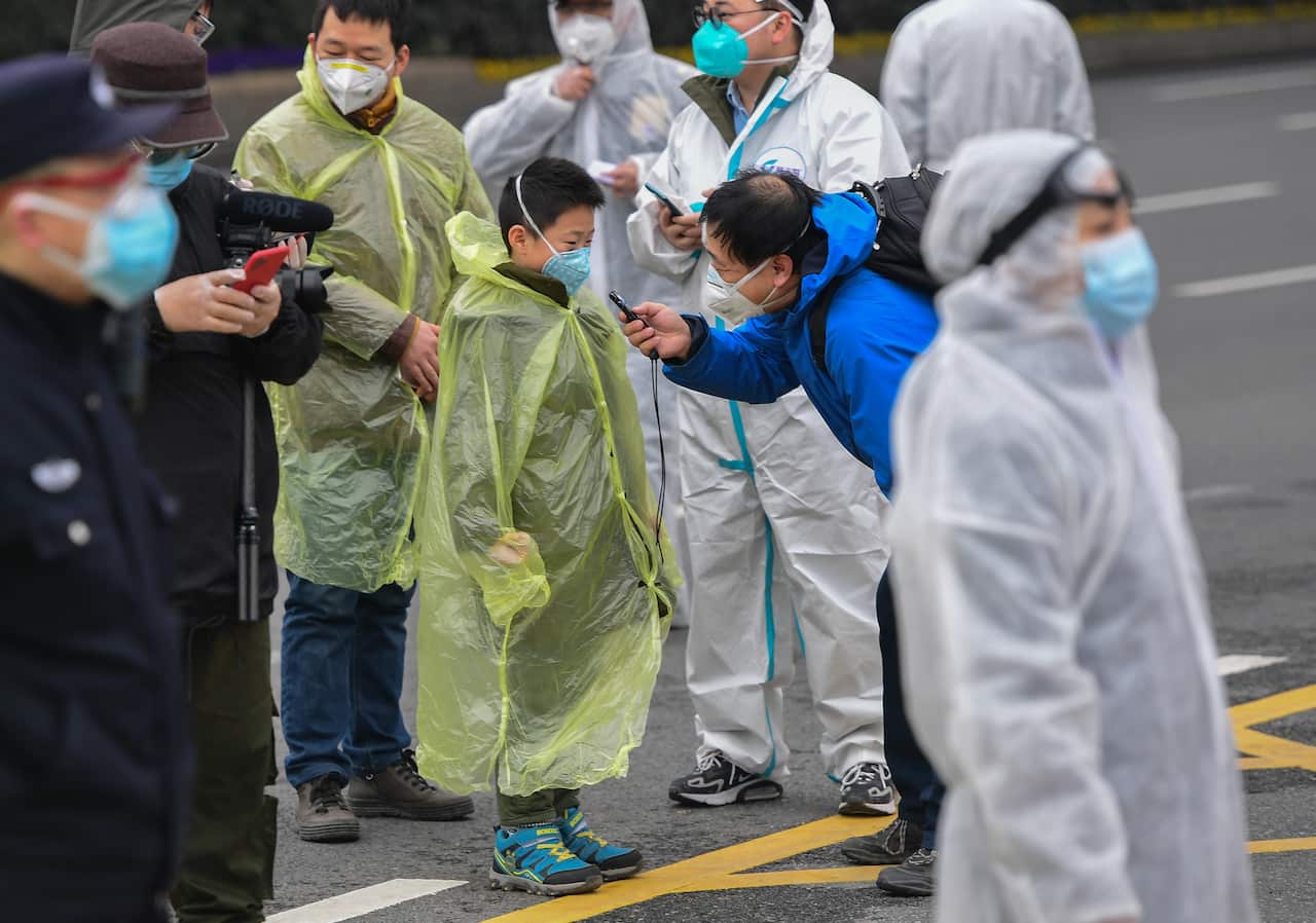 Patients speak with members of the media after being discharged from a makeshift hospital inside a Wuchang gymnasium.