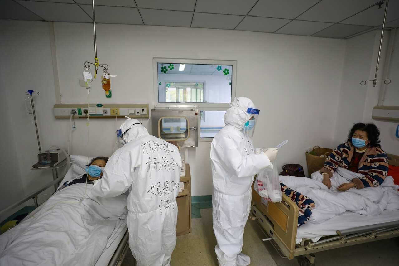 Medical officers tend to two patients inside Jinyintan Hospital, Wuhan where critical coronavirus patients are quarantined.