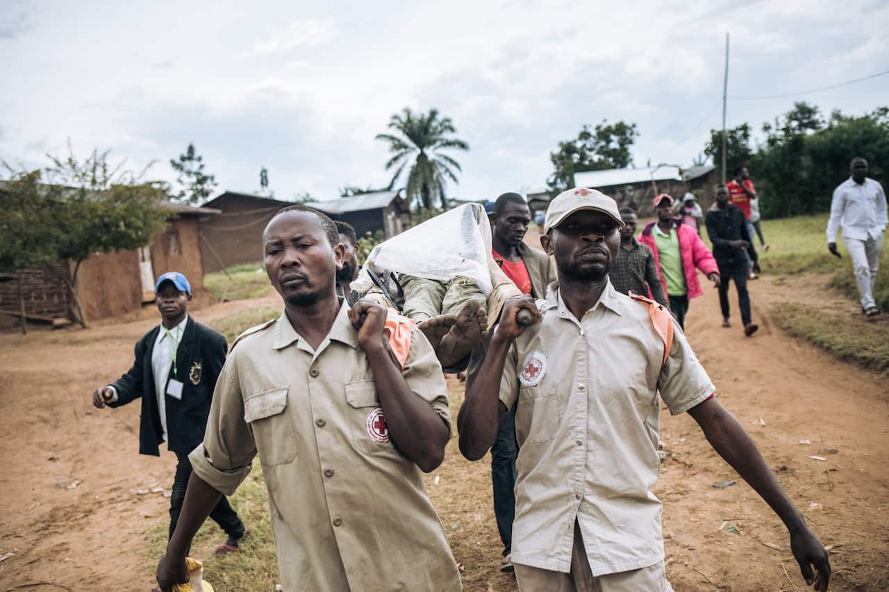 DCR’s Red Cross and relatives of a 39-year-old man carry his body after an attack allegedly perpetrated by the rebel group ADF in the a village near Beni.