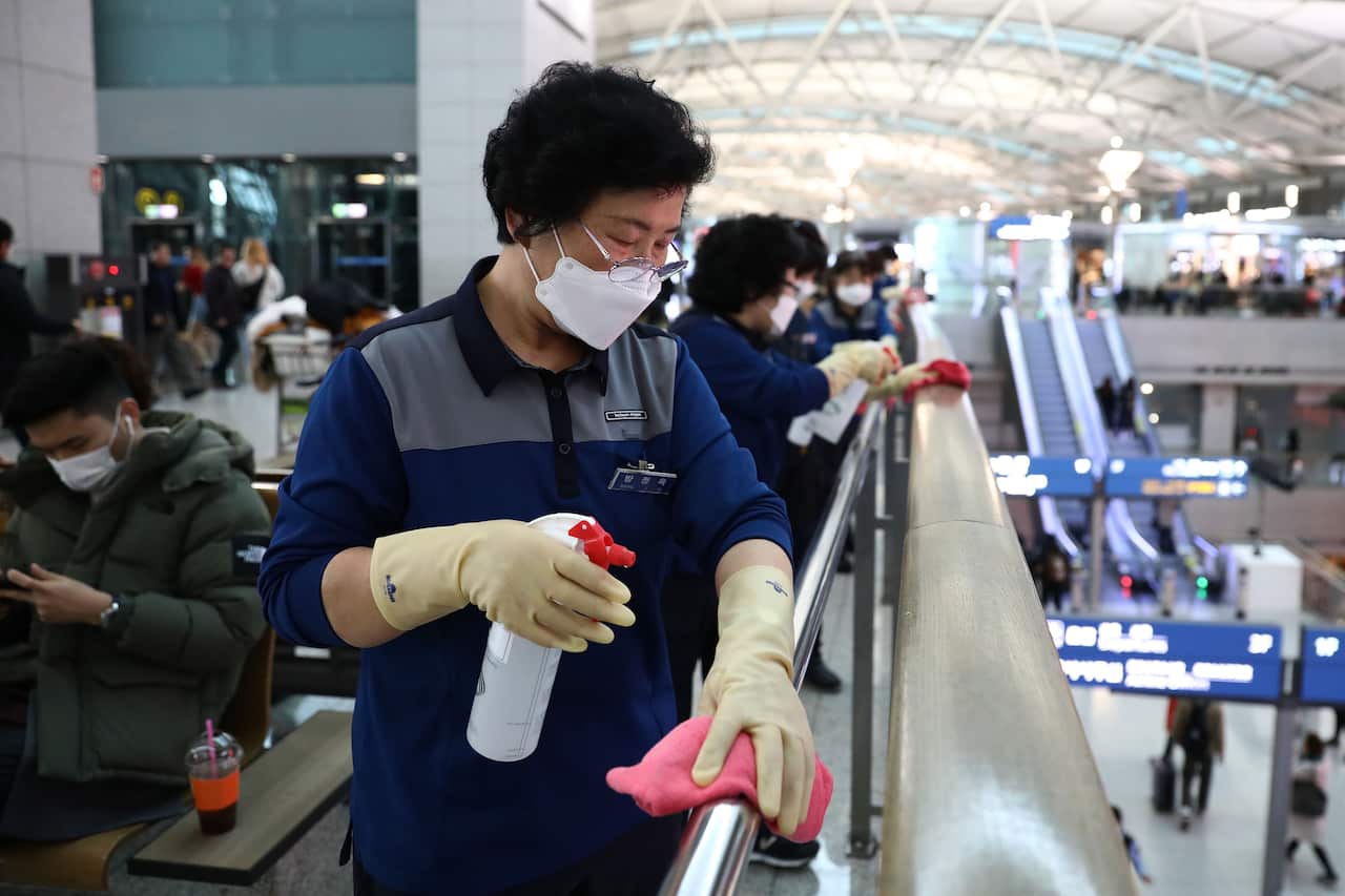Disinfection workers wearing masks spray antiseptic solution at the Incheon International Airport in South Korea.