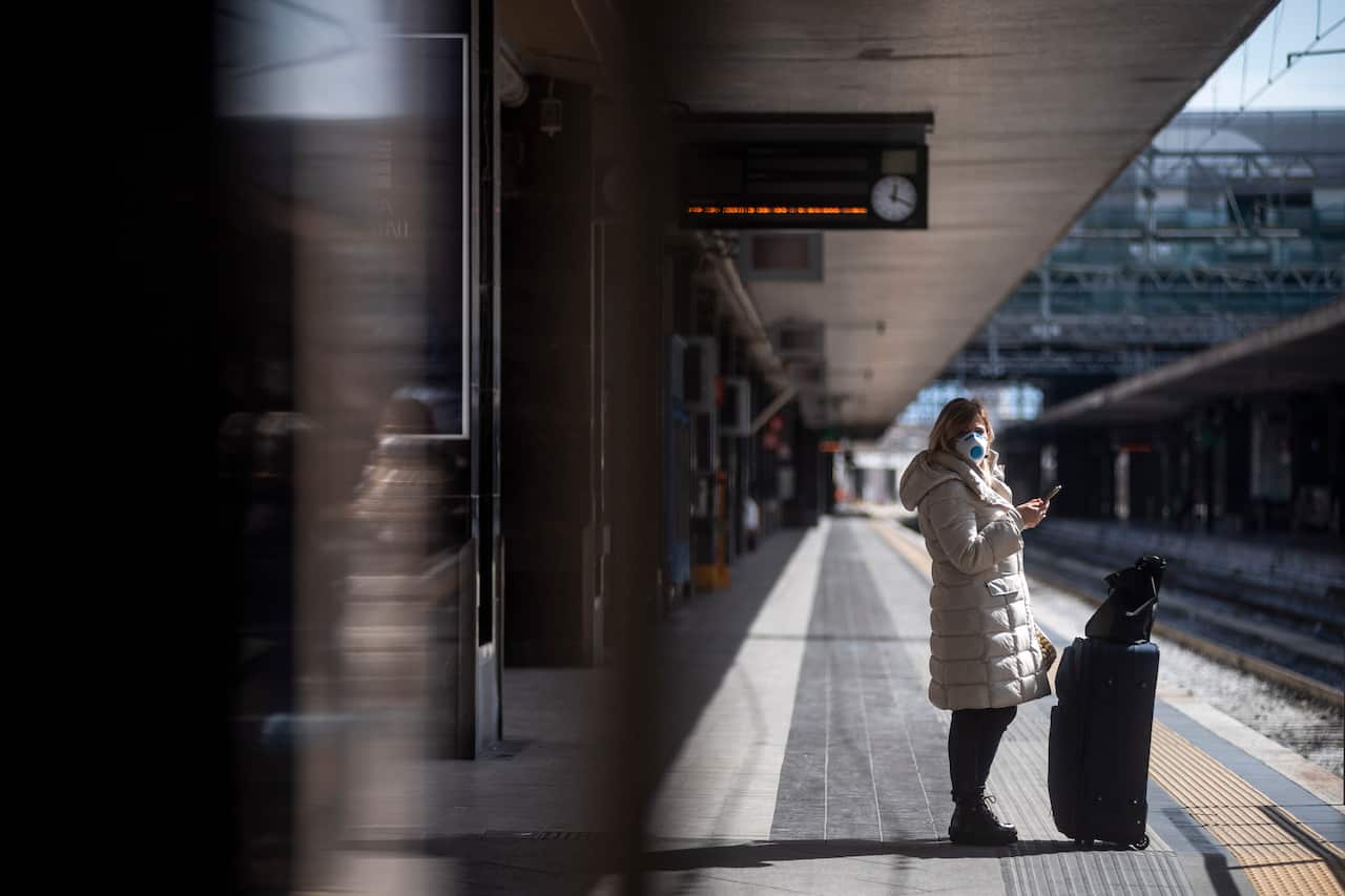 A passenger wearing a face mask waits at Termini Central Station in Rome, Italy.