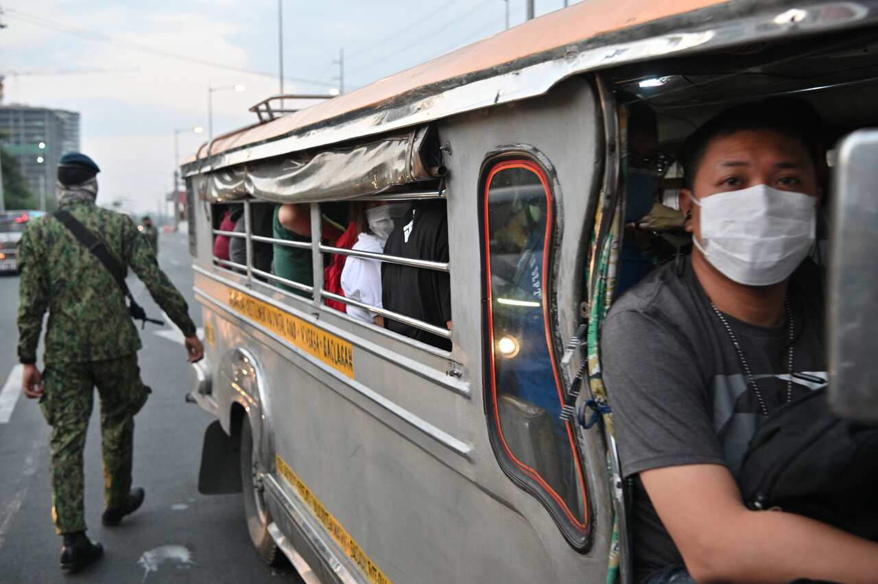 A policeman inspects a vehicle at a checkpoint bordering nearby Cavite province and suburban Las Pinas in Manila.