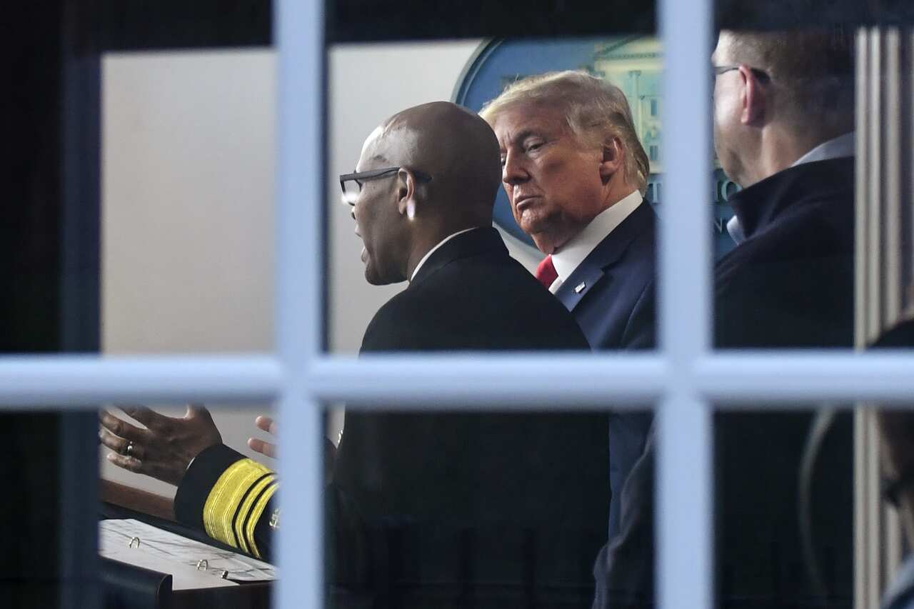 US President Donald Trump listens as US Surgeon General Jerome Adams speaks during a daily briefing on the novel coronavirus, at the White House in Washington.