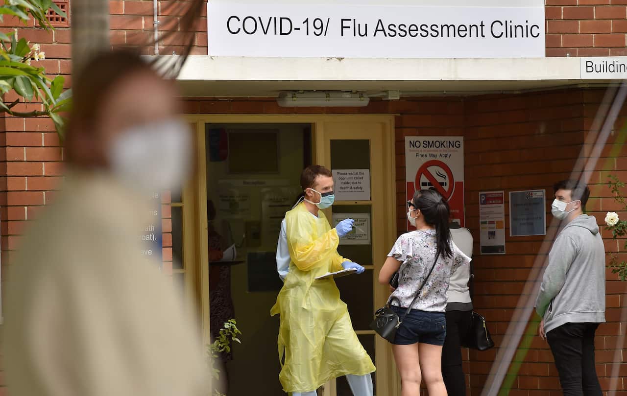 A health worker talks to visitors at a Covid-19 testing centre in Sydney on 23 March, 2020. 