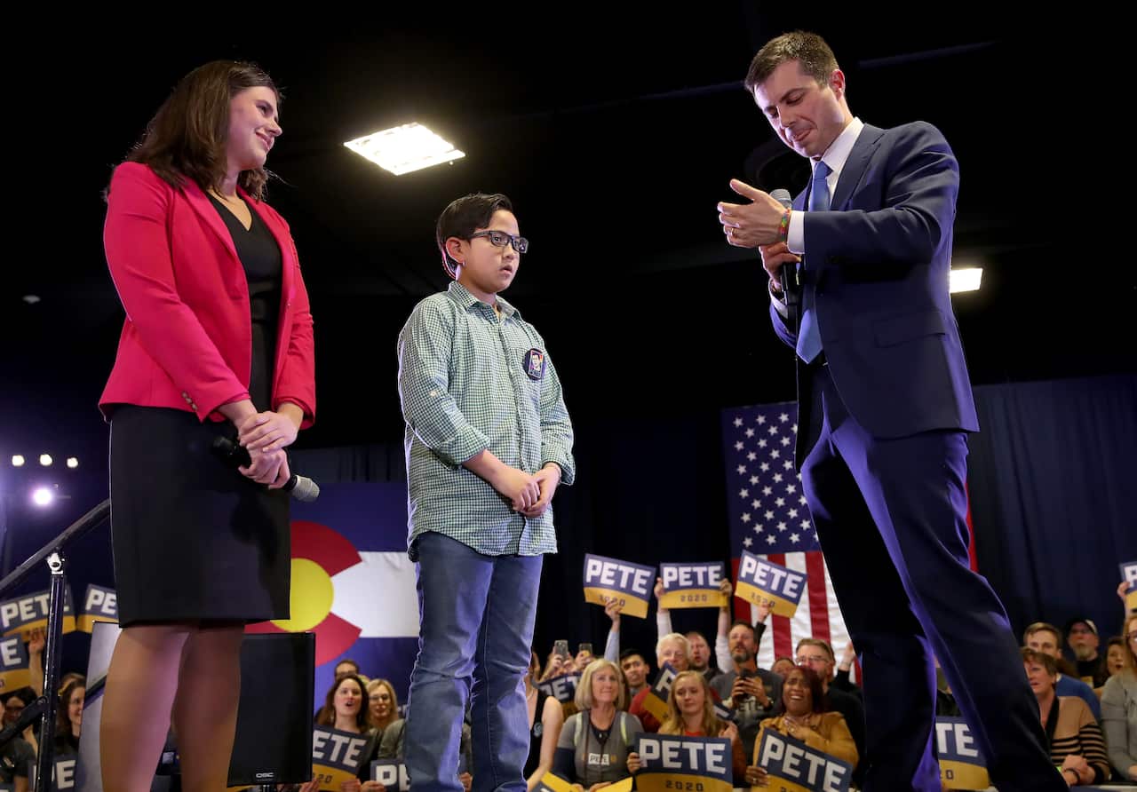 Democratic presidential candidate Pete Buttigieg accepts a bracelet from Zachary Ro, who asked the former mayor to help him tell others he is gay.