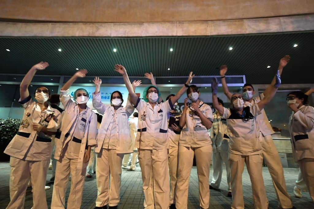 Healthcare workers dealing with the new coronavirus crisis wave in return as they are cheered on by people outside the Fundacion Jimenez Diaz hospital in Madrid