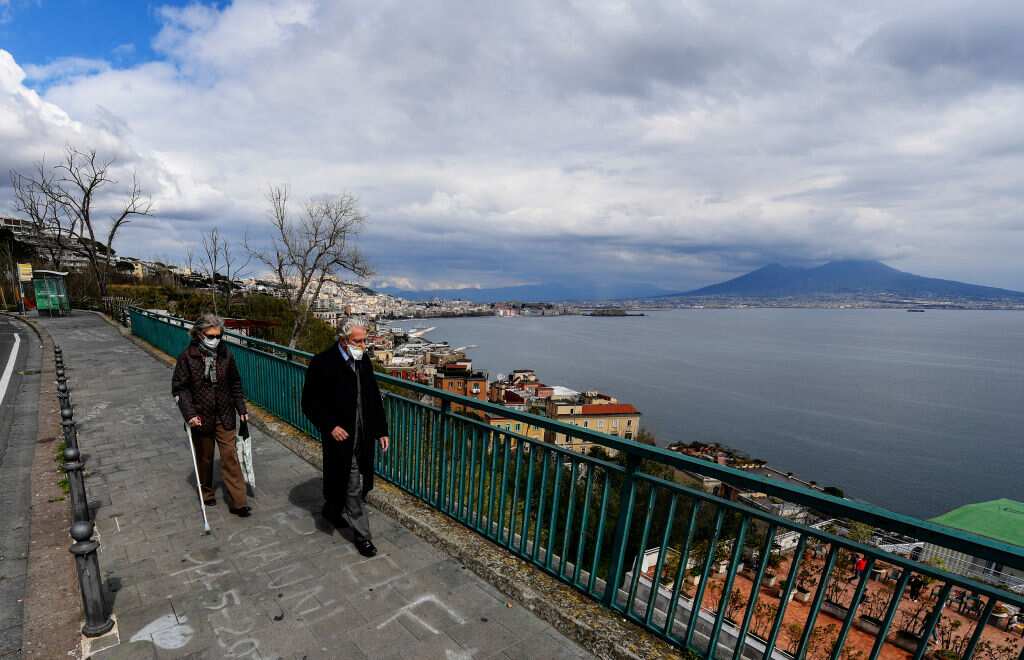 People wearing protective masks walk in the street, on
