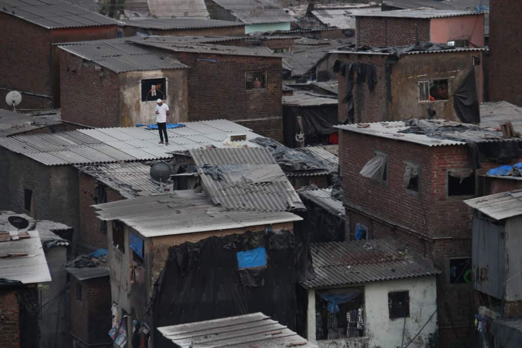 A man is seen standing atop a building in the Dharavi slum