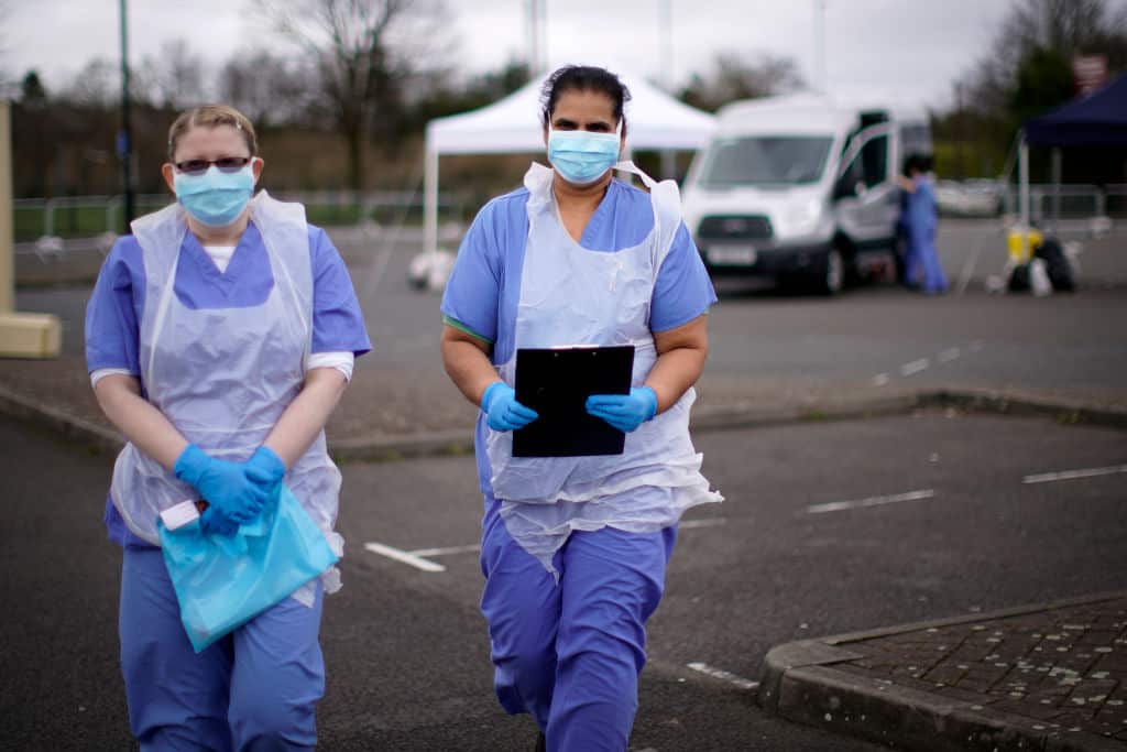 Health workers wait for the next patient at a coronavirus testing site in Wolverhampton, England.