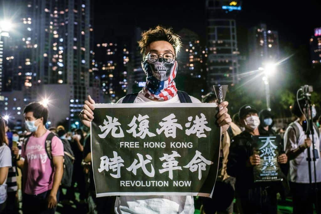 A pro-democracy protester holds a banner with pro-
