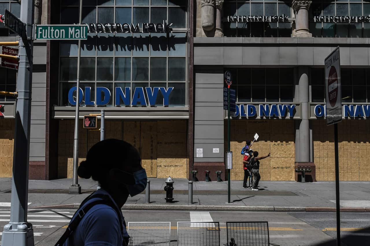 Stores remain boarded up on the first day of reopening in New York.