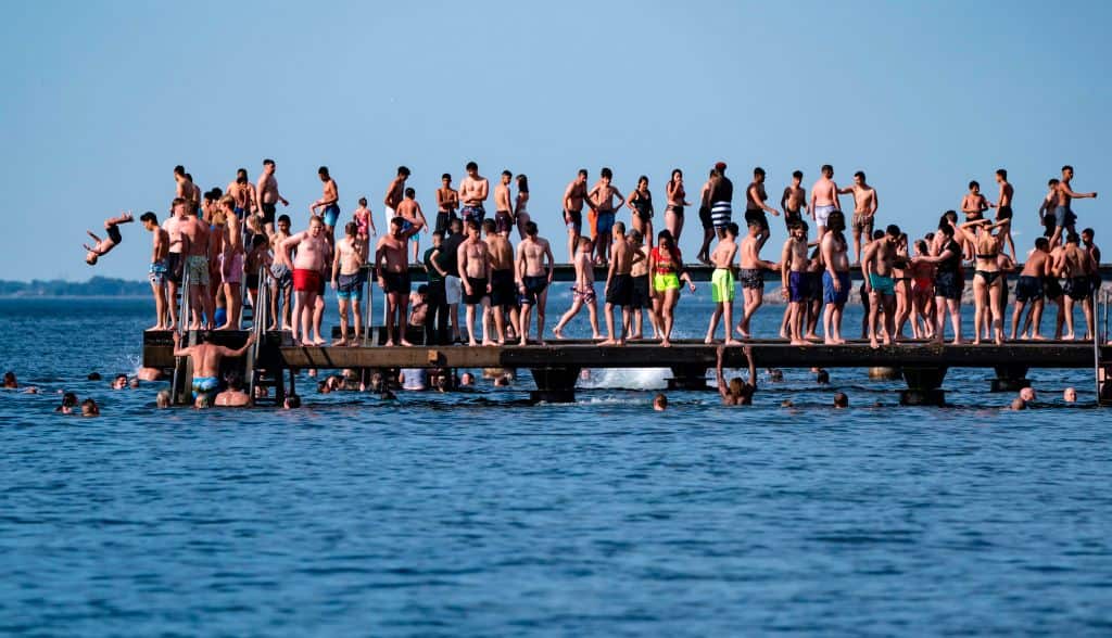 People jump off a jetty in Malmo, Sweden, during Europe's early-summer heatwave.