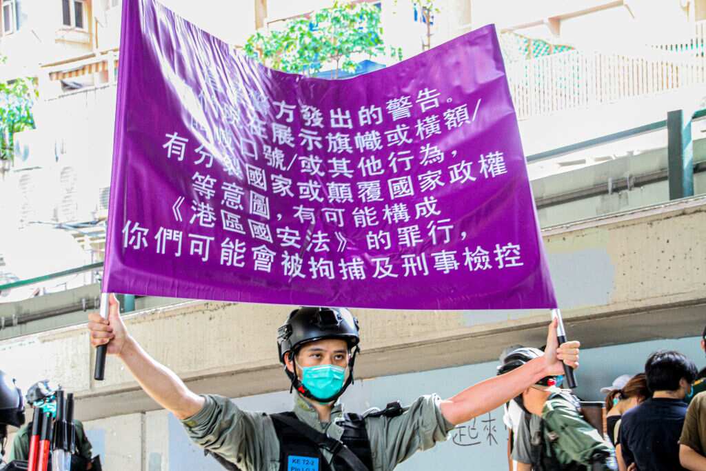 A police officer raised the purple flag to warn protesters they are breaching the new law
