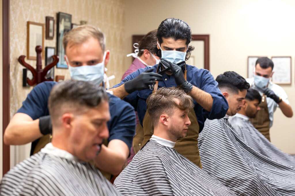 Barbers at gives haircuts to customers at The French Barber on May 14, 2020 in Wellington
