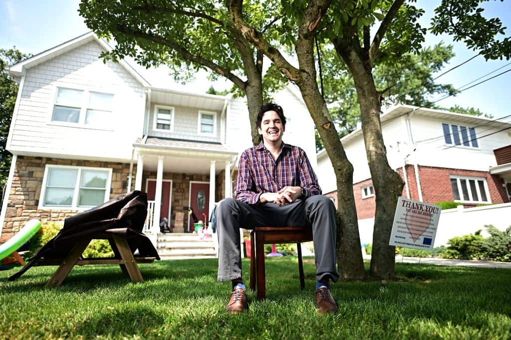 Scott Krakower poses in front of his home in Long Island, New York. Krakower says he was diagnosed with COVID-19 in April and is still experiencing symptoms.