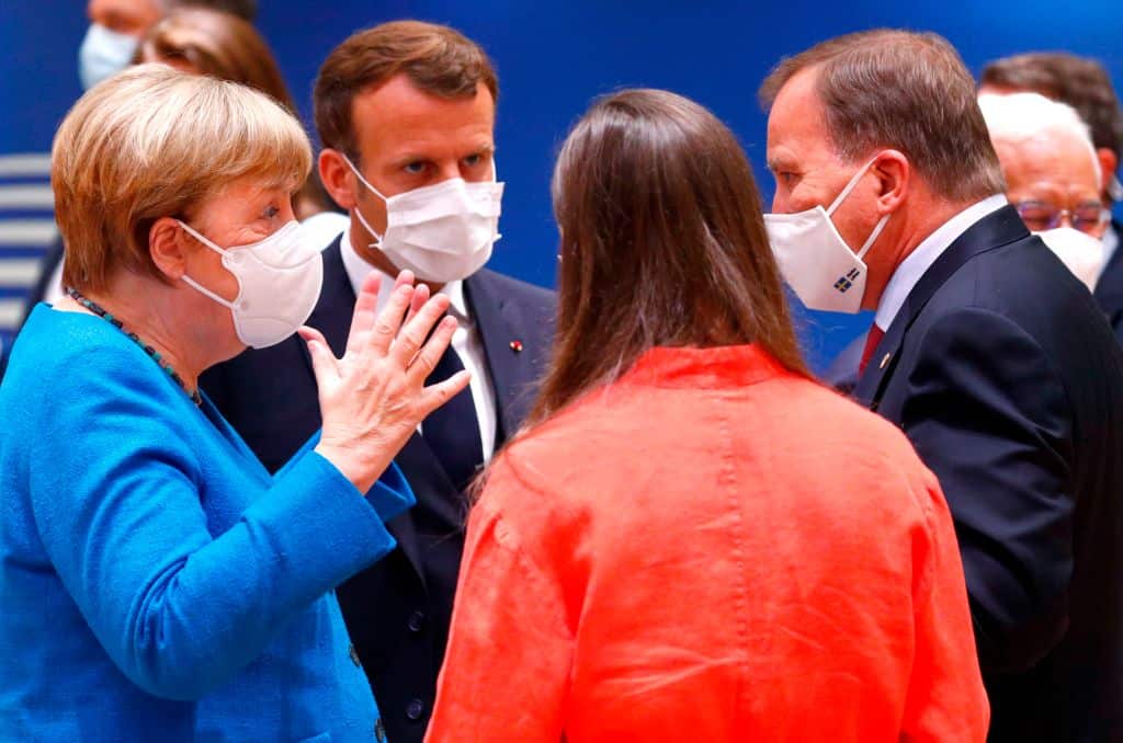 Germany's Chancellor Angela Merkel gestures as she speaks with France's President Emmanuel Macron and Sweden's Prime Minister Stefan Lofven