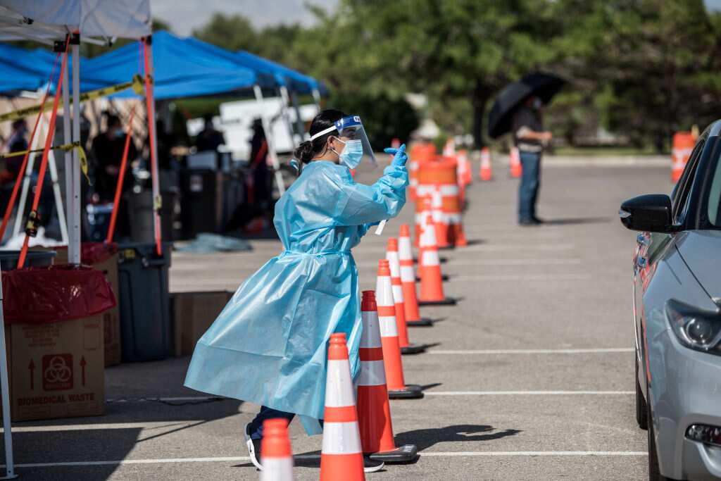 A nurse beckons to people in a car at a newly opened mega drive-thru site at El Paso, Texas.