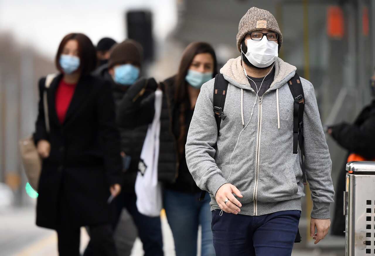 Commuters walk past Melbourne's Flinders Street Station on 23 July, 2020 on the first day of the mandatory wearing of face masks in public areas.