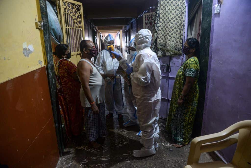 A health worker checks the body temperature of a resident during a door-to-door COVID-19 coronavirus screening in a Mumbai slum area