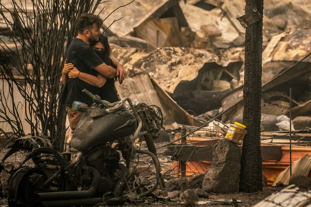 Shawn Thompson hugs Melissa Vuckovich after an unsuccessful search for their missing cat where their home once stood in Ashland, Oregon on 11 September.