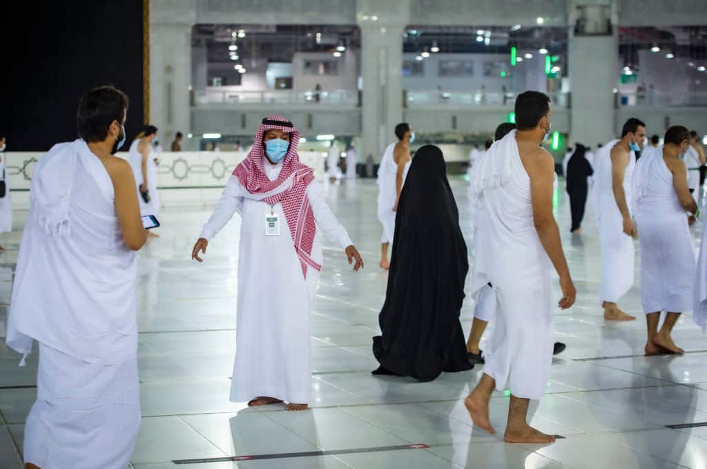 A staff member monitors proper distancing as Saudis and foreign residents circumambulate the Kaaba in the Grand Mosque complex in the holy city of Mecca. 