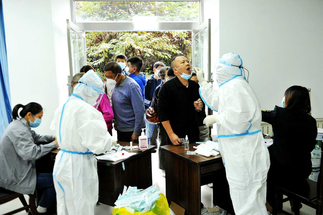 Medical staff gave a throat swab nucleic acid test to a resident in Qingdao.